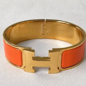 Продается яркий винтажный браслет Hermes Clic Clac в оправе золотого цвета в очень хорошем состоянии